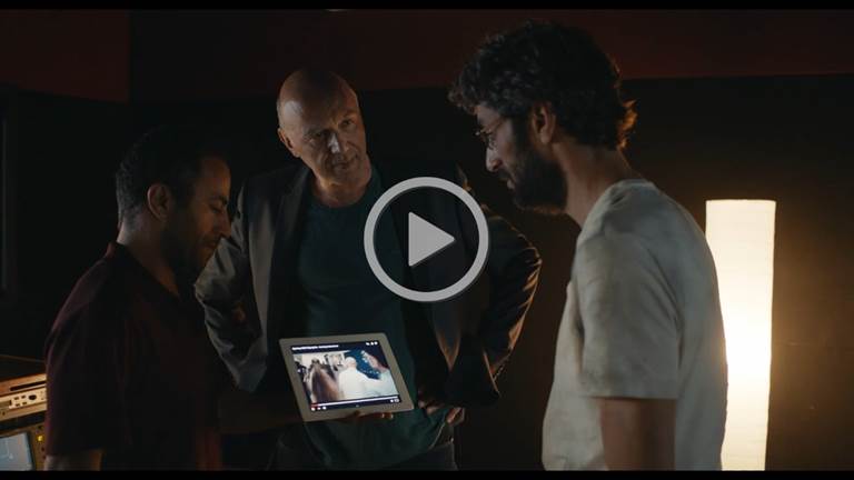 A group of men looking at a tablet

Description automatically generated